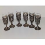 A set of six embossed 'Sterling' silver absinthe glasses, the openwork sleeves decorated with roses,