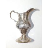 A Georgian embossed silver cream jug - TS, London 1782, 4.6" high.