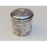 An art nouveau embossed silver dressing table jar of cylindrical form, the cover decorated with a