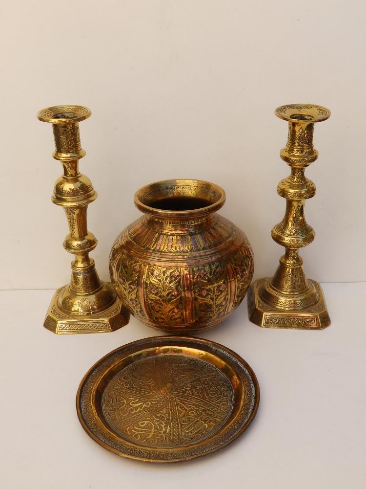 A brass Cairo ware vase, 5.5" high, two 9" candlesticks and a 6.5" circular tray. (4)