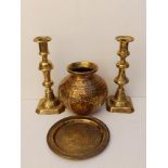 A brass Cairo ware vase, 5.5" high, two 9" candlesticks and a 6.5" circular tray. (4)