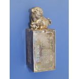 A 19thC Chinese silver medicine box surmounted by a Buddhistic lion, calligraphic inscriptions to