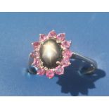 A small ruby cluster ring with central 'star' cabochon. Finger size Q.