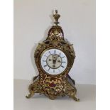 A red boulle mantel clock with visible Brevette escapement, 14.5" high
