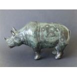 A Chinese bronze rhinoceros, 8" across.