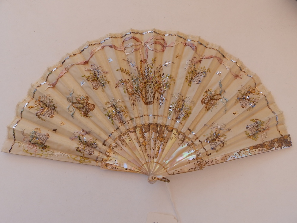 A 19thC mother-of pearl fan, the silk leaf decorated with embroidery and sequins, 15.5" across, in
