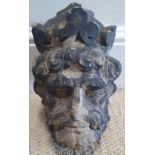 An antique stone carving depicting the head of a king, 9" high.