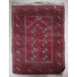 An Oriental prayer rug, of geometrical pattern on red ground, 45" x 34".