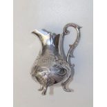 A George III embossed silver baluster cream jug standing on three leaf cast scroll feet - JS…,