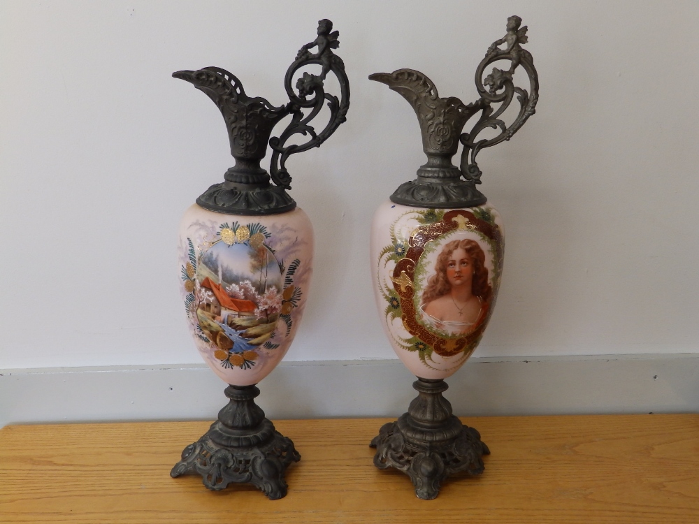 Two continental spelter mounted pink glass ornamental ewers, one decorated with a female portrait,