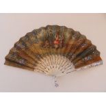 An early 19thC mother-of-pearl fan, the paper leaf painted with a young dancing couple to one