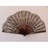 A tortoiseshell effect fan, the black gauze leaf decorated with cream silk flowering foliage and
