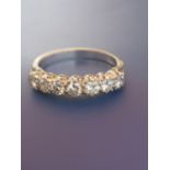 A seven stone diamond ring in 18ct white metal. Finger size M/N.