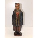An old painted terracotta figure depicting a young female wearing a clock and cross, 10.5" high =