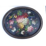 An oval painted metal Russian tray decorated flowers on black ground, 20" across.