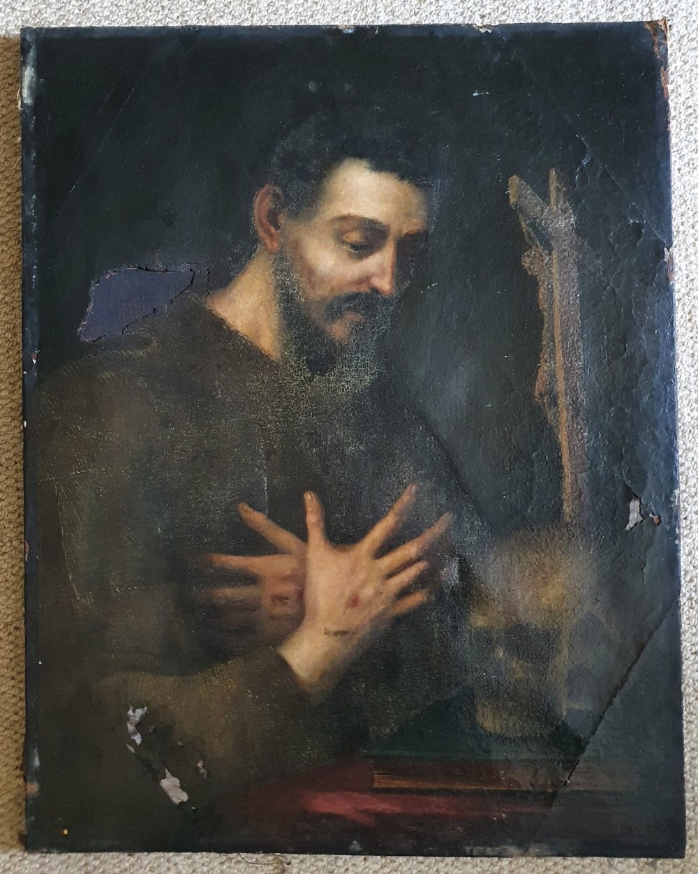 An antique oil on canvas depicting a monk in contemplation before a crucifix and skull, 29" x 22.