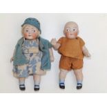 A small pair of bisque head girl & boy dolls with painted googly eyes, 5". (2)