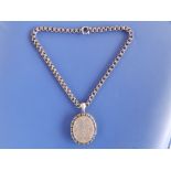 A Victorian engraved silver oval locket on chain., 1.9" excluding loop, on 16" chain.