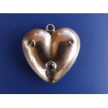 A gold heart pendant set with three diamonds, 1.25".