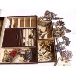 A dark brown jewellery box containing a modern dragonfly brooch and butterfly brooch and other