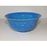 A Chinese blue glazed bowl decorated in relief with a dragon, seal mark to underside, 6.3"