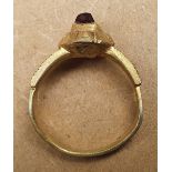 A 15thC silver-gilt finger ring with square cut garnet.