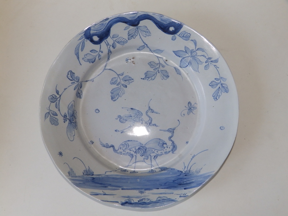 An 18thC English blue & white delft charger, the chinoiserie decoration showing three cranes and