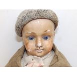 A wax-headed boy doll with blue paperweight eyes, 18" overall.