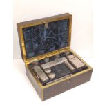 An early Victorian brass inlaid rosewood toiletry box and contents of silver mounted glass fittings,