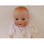 An Armand Marseille bisque head baby doll with blue paperweight eyes, open mouth, composition body -