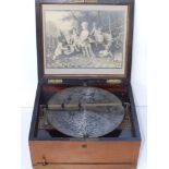 An early 20thC Symphonian disc playing musical box, in walnut case with 18 10" discs, the box 13"
