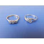 A two stone diamond crossover set ring and one other. (2)