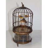 A small 20thC automaton bird cage clock, two birds above a spherical chapter ring, 7.5" high