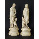 A pair of 19thC continental ivory figures, each depicting a semi-nude female with an infant at her