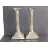 A pair of Edwardian silver corinthian column square based candlesticks with beaded edges, CB