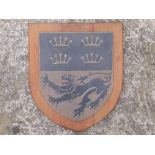 A heavy wood-mounted metal shield-shaped plaque with engraved & painted heraldic decoration