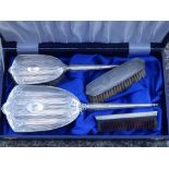 A modern cased silver dressing table brush set.