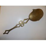 A decorative brass chestnut roaster of oval shape, 21" overall.