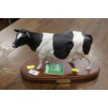 Royal Doulton Fresian cow ornament on wood plinth