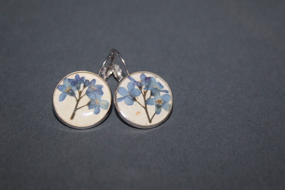 A pair of white metal earrings,