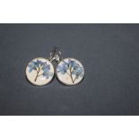 A pair of white metal earrings,