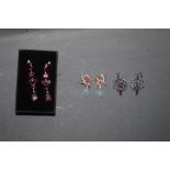 A pair of white metal and purple stone earrings of Art Nouveau design and two other pairs of