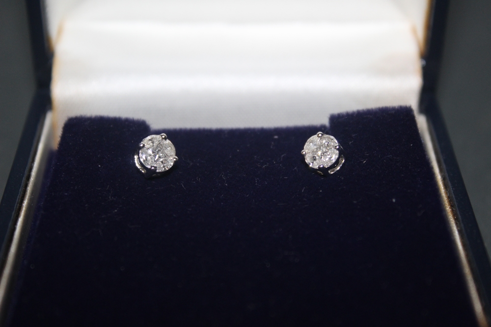 A pair of platinum and diamond stud earrings, combined approx weight 0.