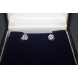 A pair of platinum and diamond stud earrings, combined approx weight 0.