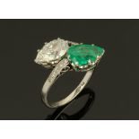 An early 20th century platinum diamond and emerald set crossover ring,