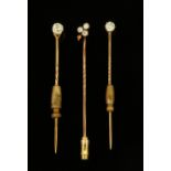 Three gold coloured metal and diamond set stick pins, two set with single stones (0.2 & 0.