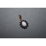A 9ct gold opal and blue stone (Thought Sapphire) oval pendant the central cabochon opal surrounded