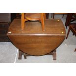 An oak oval gate leg table with turned e