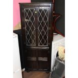 An oak and leaded glazed corner cupboard