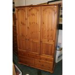 A large modern pine triple wardrobe, with three doors and five drawers, height 200 cm, width 124 cm,